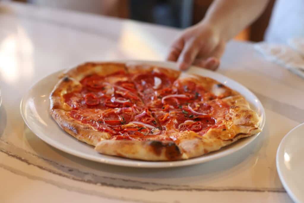 A pizza being served at Wolfgang Puck Bar & Grill Orlando